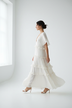 Robe étagée encolure crantée manches courtes BLACK-COAT - vue de profil latéral montrant mannequin en mi-pas, drapé naturel du tissu, silhouette étagée en mouvement et proportions élégantes sur fond blanc studio