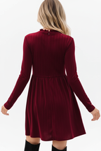 "Robe mini velours bordeaux col volant - vue arrière dos montrant le design du dos de la robe velours, manches longues ajustées, jupe mini évasée, texture velours bordeaux luxueuse, fond blanc studio BLACK-COAT"