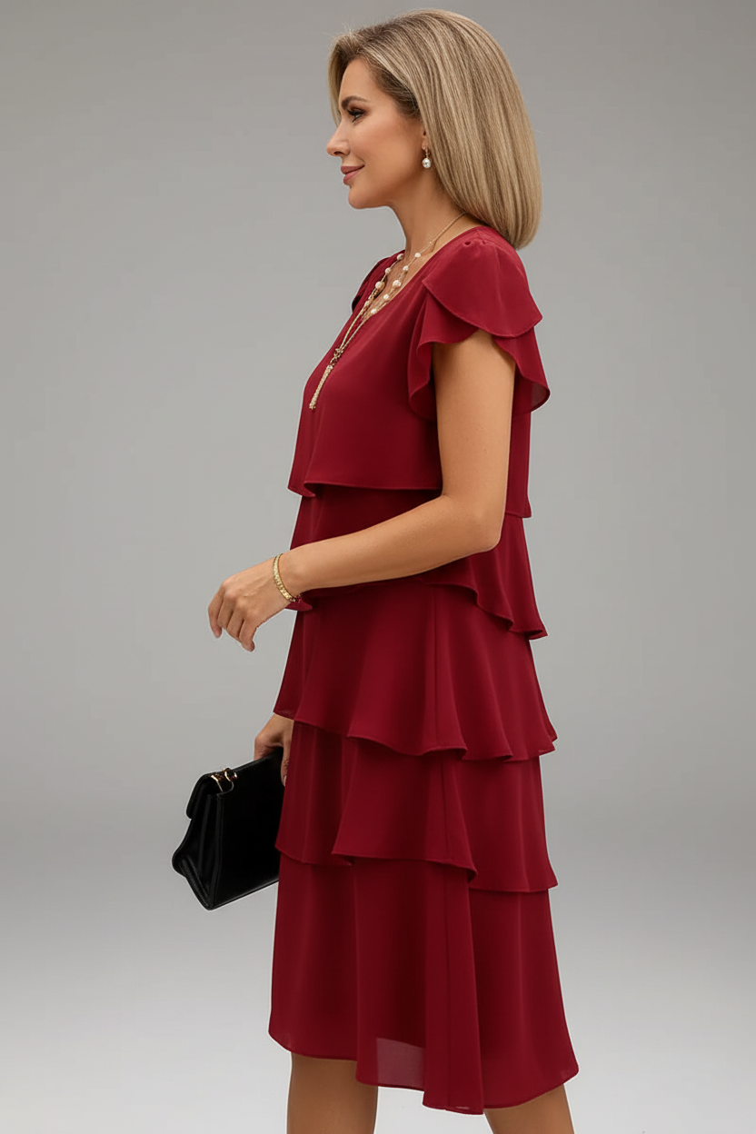  Vue de profil : Robe grande taille rouge bordeaux à volants étagés et manches pétales - vue de profil révélant le mouvement gracieux des volants superposés créant effet cascadant élégant, la silhouette midi sophistiquée et comment chaque couche ajoute dimension visuelle captivante et romantique - BLACK-COAT